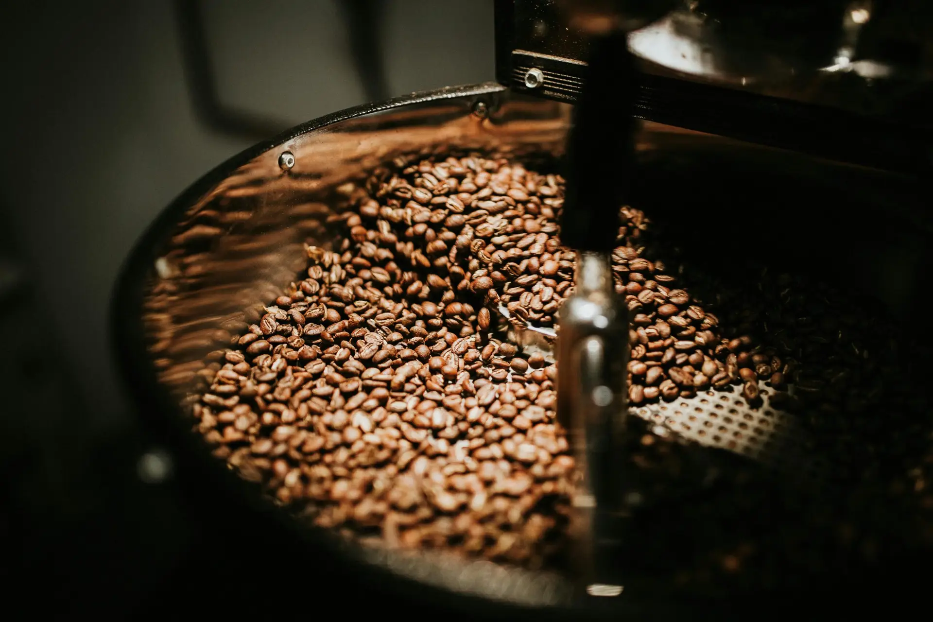 pexels-photo-894695-894695 Close-up of freshly roasted coffee beans in a large industrial coffee roaster, showcasing rich textures and warm tones.